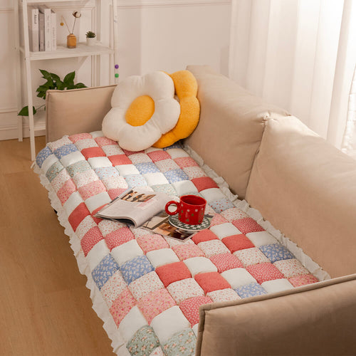 Pink and Blue Patchwork quilted mat on a cream sofa