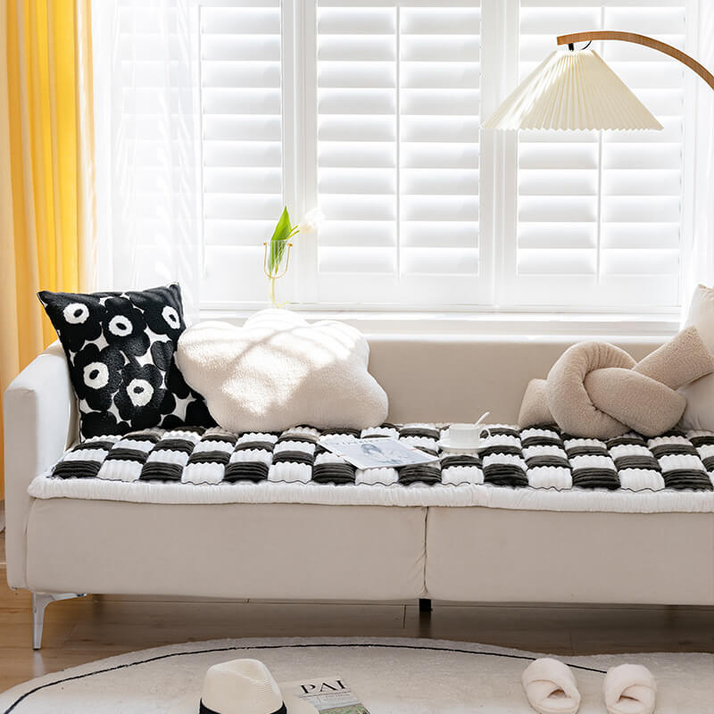 Black and cream ribbed checkerboard pet mat on a sofa