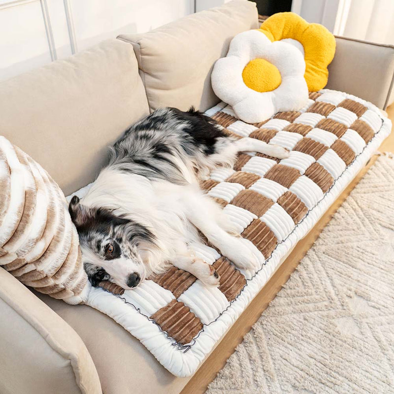 Brown and cream ribbed checkerboard pet sofa mat with a dog resting on it