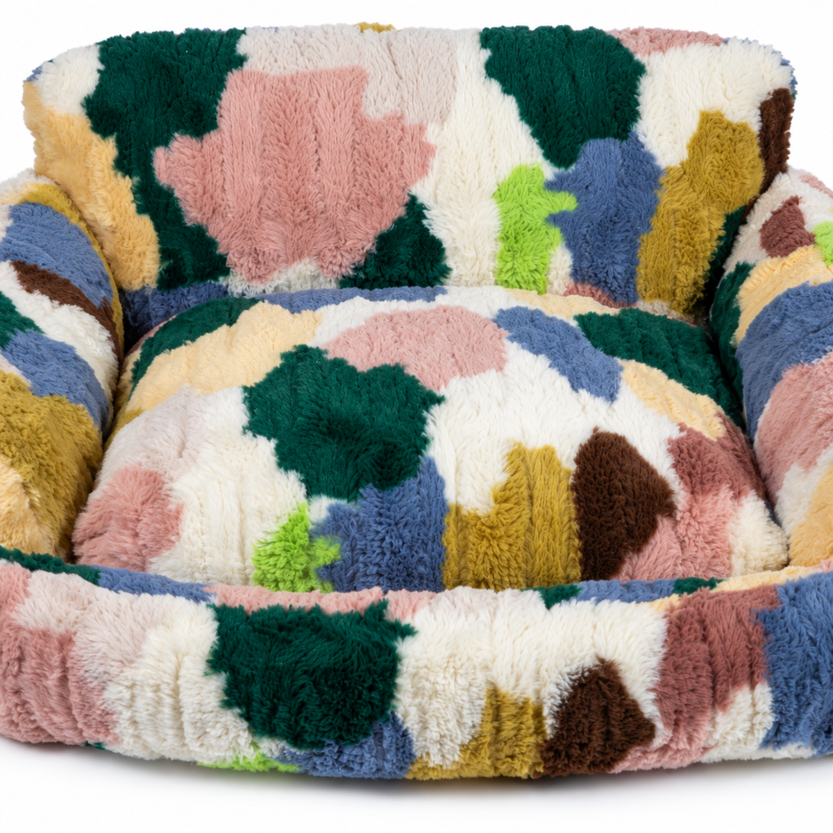 Elevated close-up of the multicolor plush seat cushion fitting inside the pet nest's curved front and side bolsters.