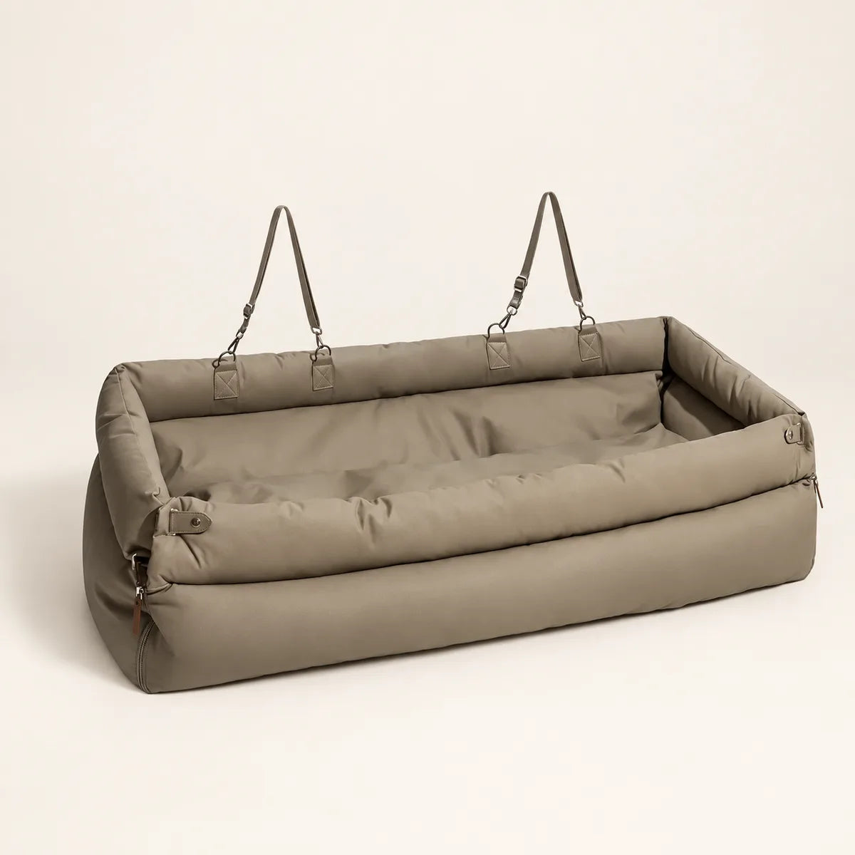 Grey long pet car seat bed with padded sides and straps on a warm cream background