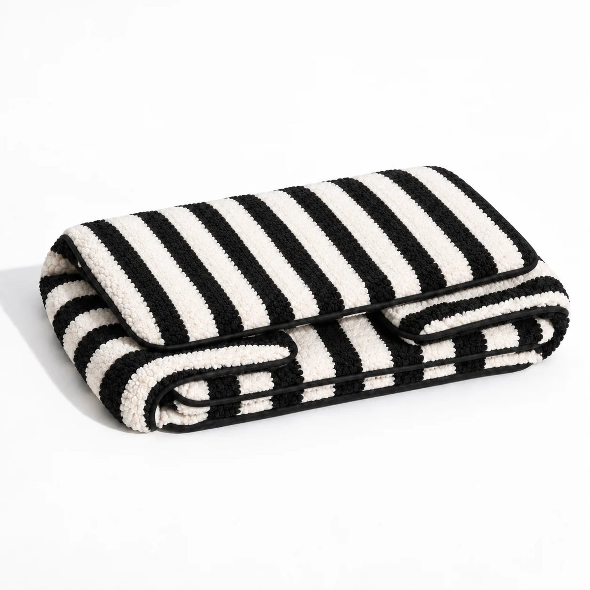Alternate studio view of a black and ivory striped faux lambswool pet sofa folded on a white background