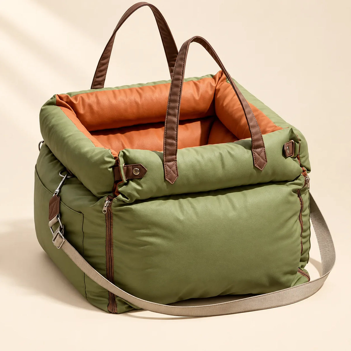 Olive green pet travel carrier with orange lining, brown handles and shoulder strap