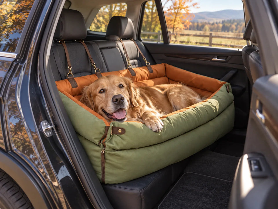 Golden retriever resting in an olive RoadNest rear-seat bed in a parked car